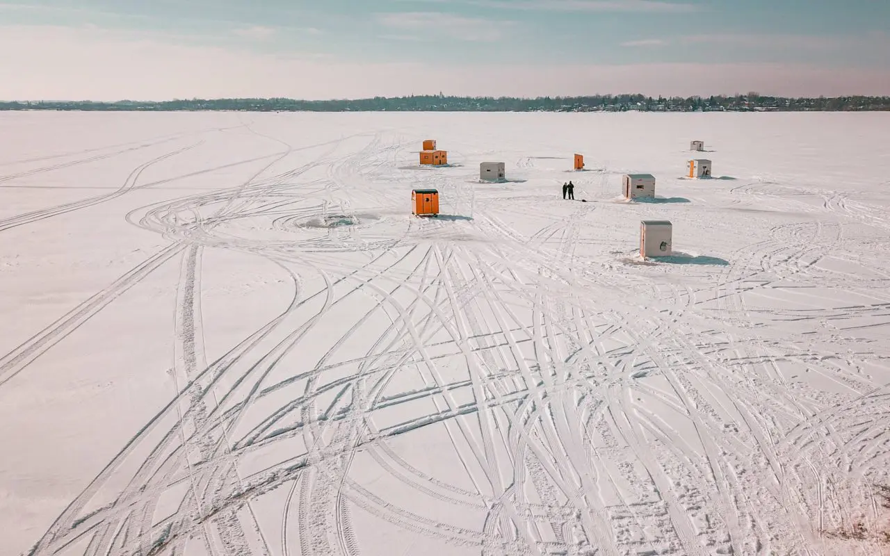several ice fishing huts out on the ice | toronto road trips