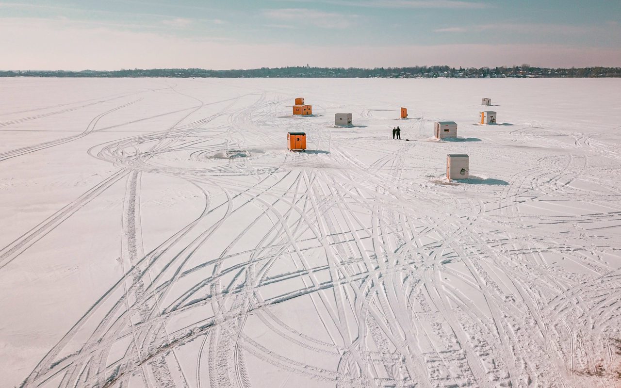 several ice fishing huts out on the ice | toronto road trips