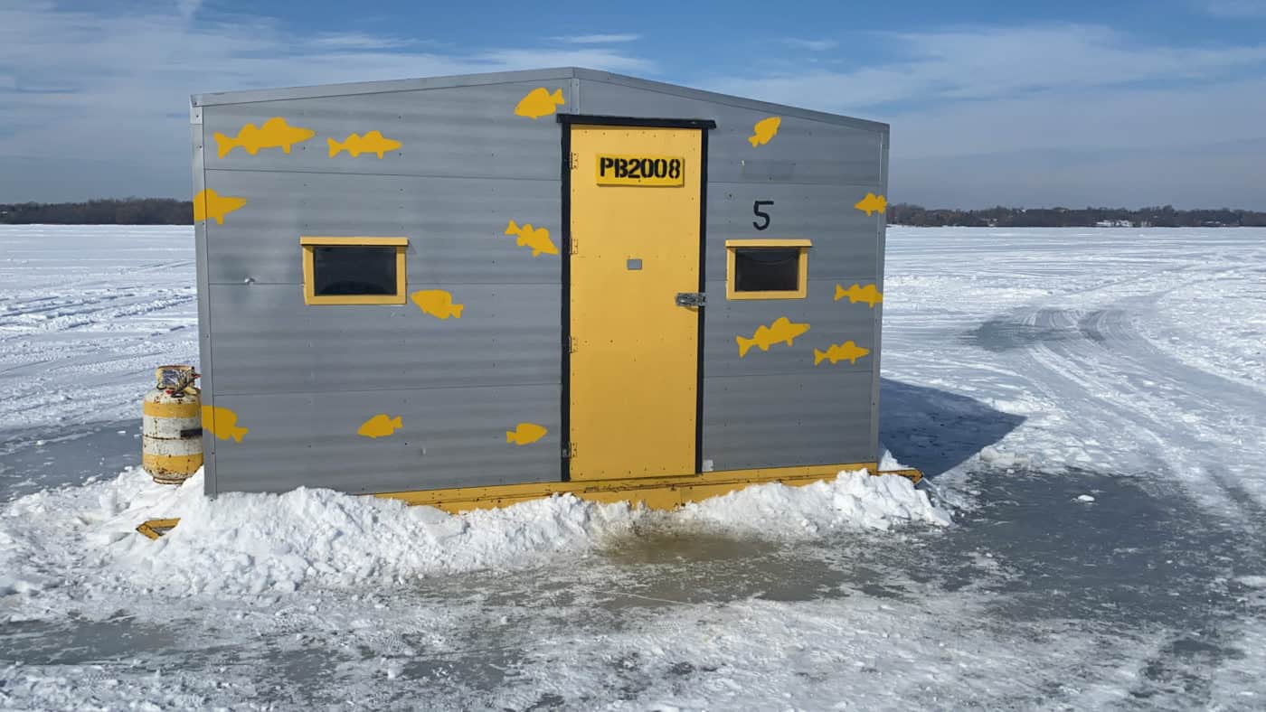 ice fishing hut on the lake surrounded by ice and snow | day trips from toronto