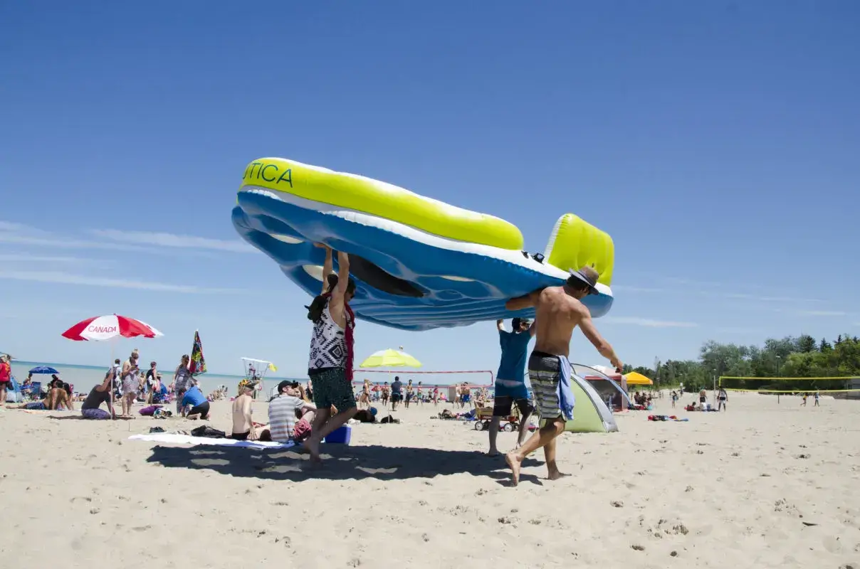 group of people carrying a large water float | top beaches in ontario