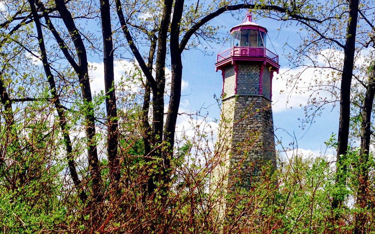 old lighthouse visible through some trees | Haunted Places in Ontario