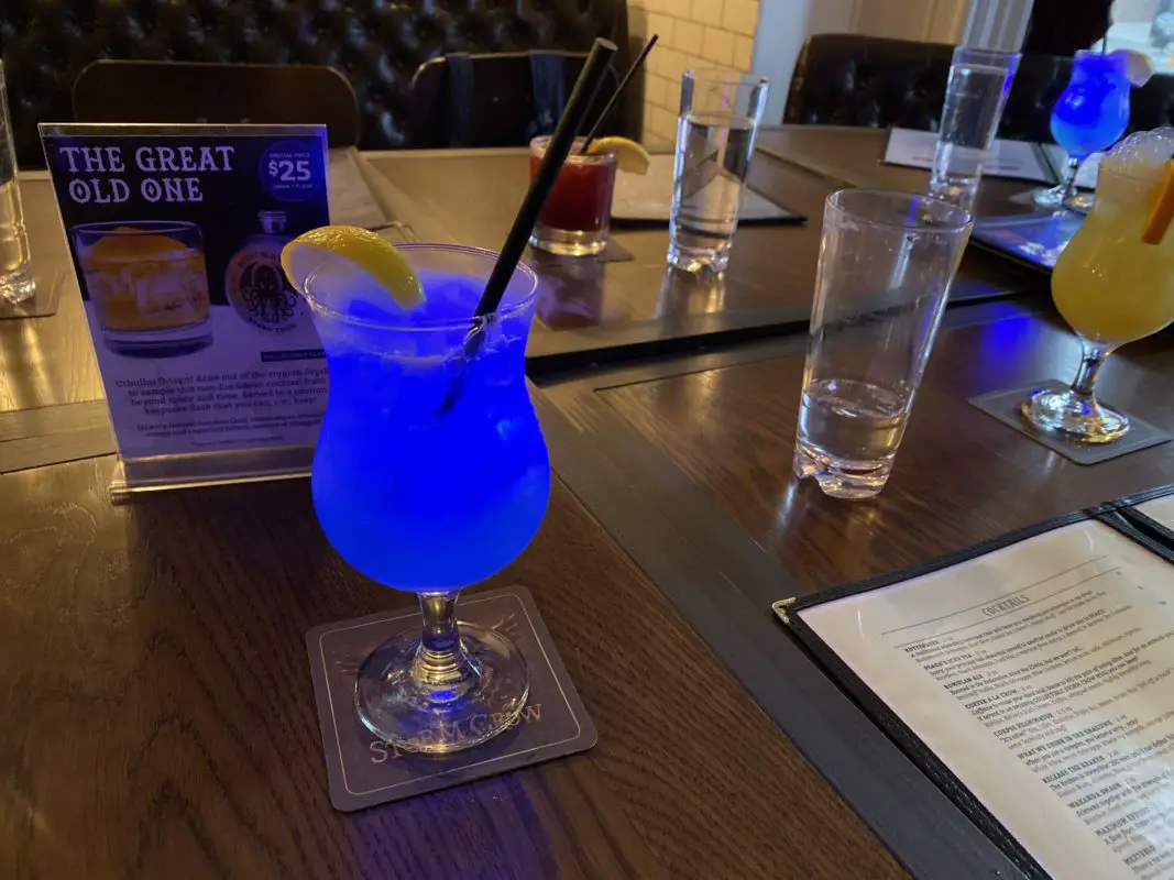 glowing blue cocktail sitting on a table next to a menu | scary places in ontario