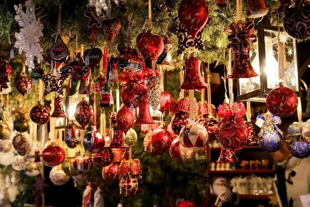 many red Christmas ornaments hanging from an overhead garland | christmas in ontario