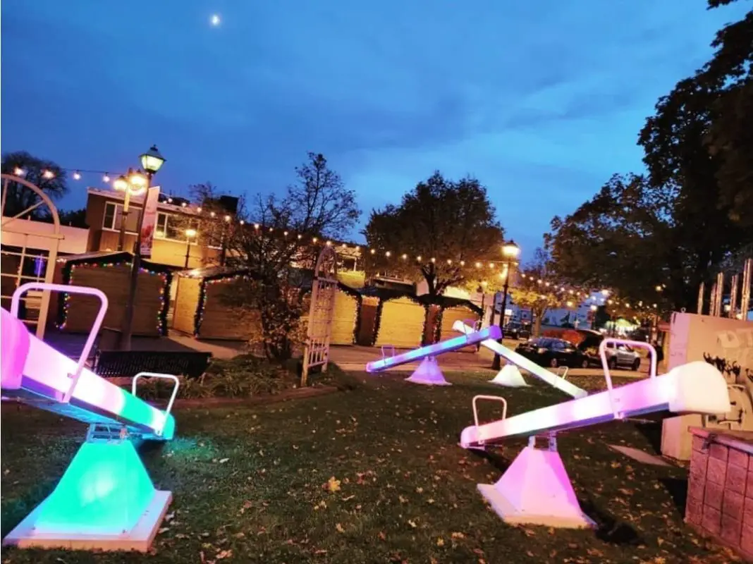 seesaws in a park lit up with bright coloured lights | christmas markets near me