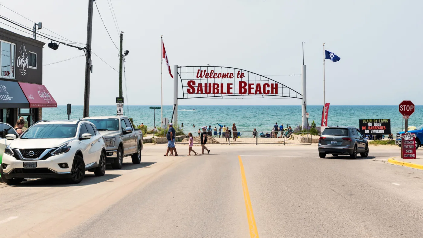 road leading into Sauble Beach with a sign | sandy beaches in ontario