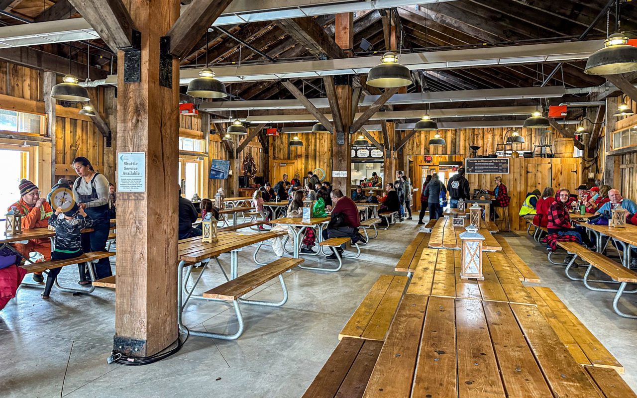view of people gathering inside a sugar shack | maple syrup festivals ontario